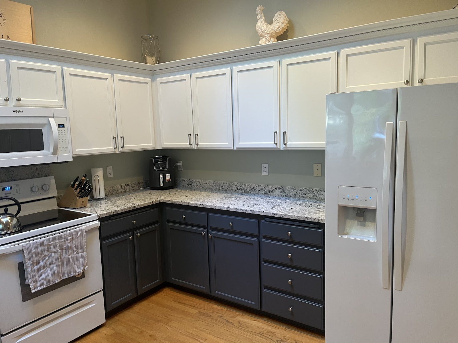 Two-tone kitchen cabinets in white and charcoal, freshly refinished